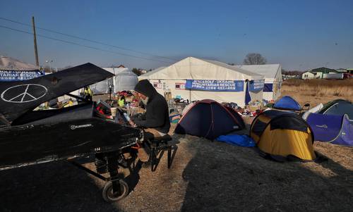 El pianista Davide Martello toca su piano durante el ingreso de los refugiados de Ucrania en la garita de Medyka-Polonia, el 20 de marzo de 2022.