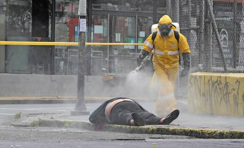  Un trabajador forense, antes de levantar el cuerpo de una mujer en una calle de Quito, Ecuador, en mayo de 2020.