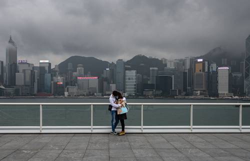  Una solitaria pareja con cubrebocas se abraza en Hong Kong el 14 de febrero de 2020 durante la explosión de covid-19 en China. Foto Afp