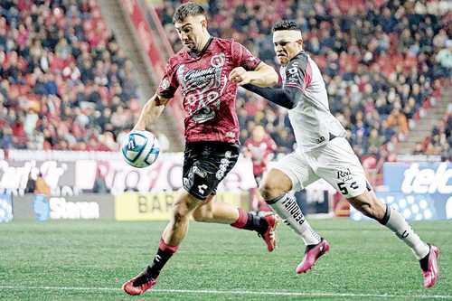 Anderson Santamaría, de los rojinegros, asedia a Lucas Cavallini en el estadio Caliente.