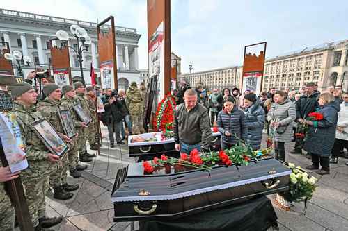 Dolientes presentan sus respetos a un padre y un hijo asesinados juntos en feroces combates en la ciudad de Bakhmut, en Ucrania.