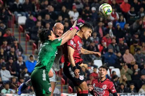 El guardameta de los Xolos, José Rodríguez, y su compañero el chileno Nicolas Díaz se defienden del asedio del delantero de los Diablos Carlos Cocoliso González en el estadio Caliente en Tijuana, Baja California.