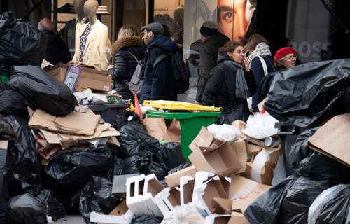 Los parisinos caminan entre montañas de basura desde el pasado día 6, cuando trabajadores del servicio de recolección estallaron una huelga en protesta por la reforma que eleva la edad de jubilación.