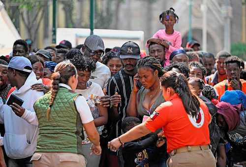 Migrantes, haitianos la mayoría, esperan para ser llevados a Puebla, Hidalgo y Querétaro, donde se les otorgará tarjeta de visitante.