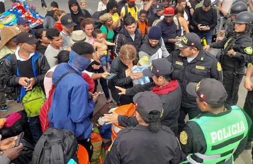 Policías peruanos impiden el paso a migrantes que desde hace días quieren cruzar por la ciudad chilena de Tacna.