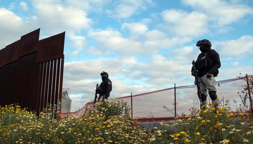 Oficiales de la Guardia Nacional mexicana vigilan una sección abierta del muro fronterizo entre Estados Unidos y México en Tijuana, Baja California.