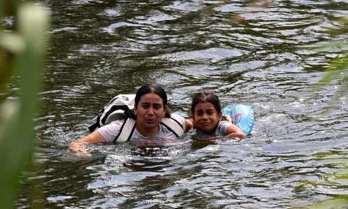 Una migrante y su hija regresan por el río Bravo a Matamoros, Tamaulipas, tras ser rechazadas por autoridades estadunidenses, ayer.