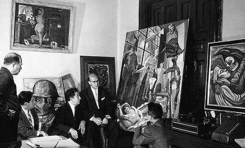 En la imagen, Hugo B. Margáin revisa junto con David Alfaro Siqueiros y el también muralista Raúl Anguiano una obra de Diego Rivera conocida como Lucila y los judas, que fue entregada como pago en especie.