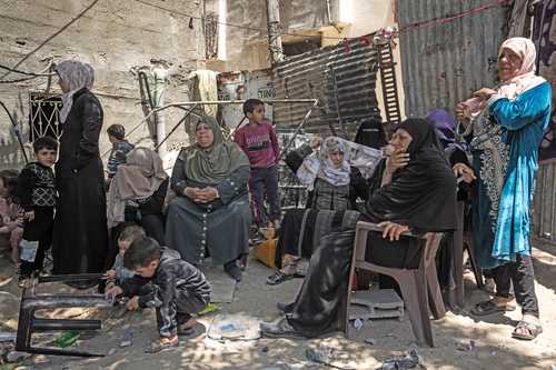 Palestinos se reúnen en las ruinas de su vivienda, que fue destruida en un ataque aéreo israelí en Jabaliya, norte de la franja de Gaza, ayer. La ofensiva dejó sin hogar a 42 miembros de la familia.