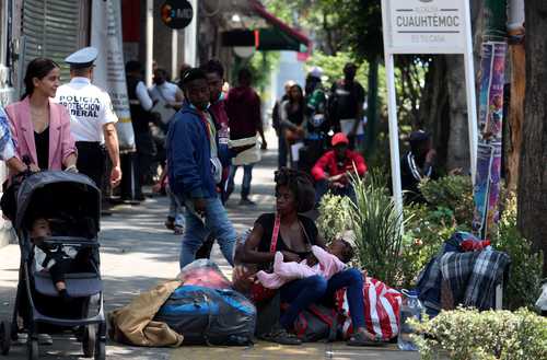 Migrantes haitianos esperan a que los atiendan en las oficinas de la Comisión de Ayuda a Refugiados, en la alcaldía Cuauhtémoc.