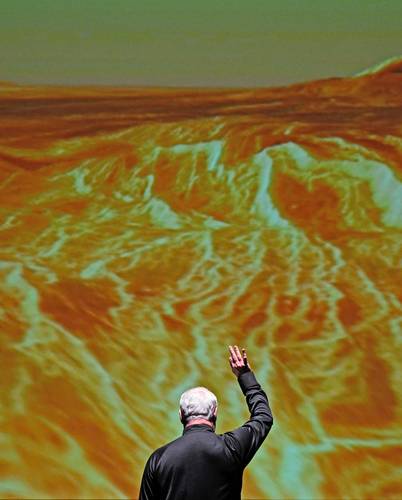 Frente a la proyección de una imagen de la NASA, el director musical y de orquesta de la Filarmónica Nacional, Piotr Gajewski, ensaya Ciclos cósmicos: Una sinfonía del espacio, del compositor Henry Dehlinger, en Capital One Hall, en Arlington, Virginia, el 10 de mayo.