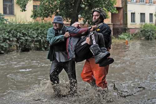 Elementos de los equipos de emergencia ponen a salvo a un evacuado que fue atacado por las fuerzas de Moscú cuando intentaba huir en bote desde la orilla este (ocupada por Rusia) del río Dniéper.