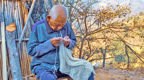 Tío Francisco tejiendo atarraya para pescar camuchin. San Matías Petacaltepec.  Heber Ramírezz