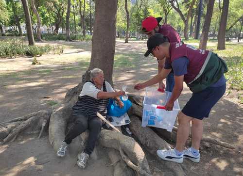 Debido a las altas temperaturas, la Secretaría de Inclusión y Bienestar Social de la Ciudad de México repartió agua y suero oral a personas en situación de calle, así como información sobre los servicios de albergue transitorio y cuidados durante el tiempo que se mantenga la ola de calor. En esta imagen, brigadistas brindan el líquido a una mujer.