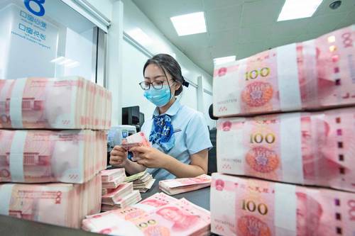 Una empleado cuenta billetes de 100 yuanes en un mostrador bancario en la provincia oriental china de Jiangsu.