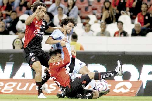 José Rivero, de Cruz Azul, resiste el asedio de los rojinegros José Abella y Aldo Rocha en el estadio Jalico.