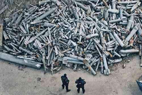 En imagen de archivo, policías en un lote de fragmentos de cohetes rusos, incluidas las rondas de racimo que impactaron en Járkov, Ucrania, el 3 de diciembre de 2022.