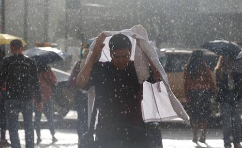 Las precipitaciones acompañadas de fuertes vientos la tarde de ayer dejaron encharcamientos y caídas de árboles en varios puntos de la ciudad; elementos del Heroico Cuerpo de Bomberos trabajaron en el desfogue del agua de diversas vialidades. Ante ello, la Secretaría de Gestión Integral de Riesgos y Protección Civil activó la alerta amarilla para ocho alcaldías. En la imagen, un usuario del Metrobús intenta protegerse del aguacero.