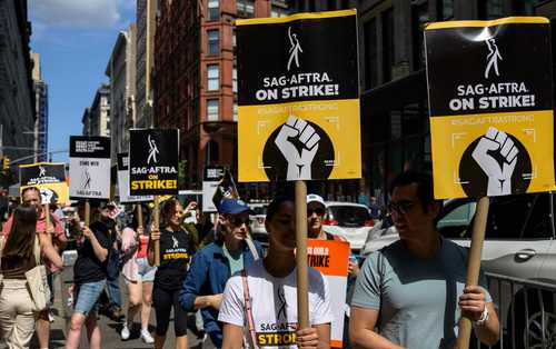 Afiliados al gremio de guionistas se manifiestan afuera de las sedes de Netflix y Warner Bros en Nueva York.
