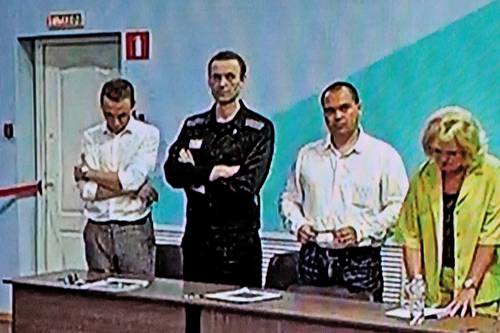 Una pantalla de video muestra a Aleksei Navalny (segundo de izquierda a derecha), quien escucha su condena sobre cargos de extremismo en la colonia penal IK-6, una prisión de máxima seguridad unos 250 kilómetros al este de Moscú.