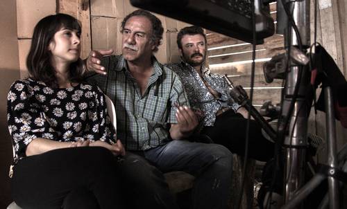 El cineasta Víctor Gaviria (al centro), acompañado de los actores Adriana López y Tito Alexander, en el rodaje de una de sus cintas. En la pantalla de contenido destaca el título de La vendedora de rosas, obra de culto en la cinematografía colombiana.