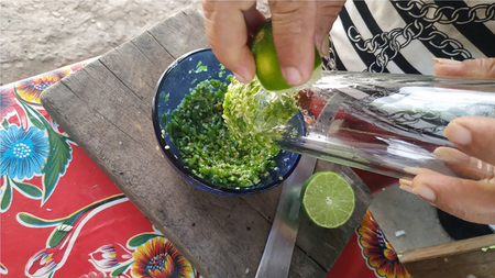 Figura 3. Tamulando frutos de chile maax para la salsa. Se observa en la imagen ingredientes como chile maax y limones, así como los utensilios de cocina que se utilizan para el procedimiento. Virginia Solís Montero