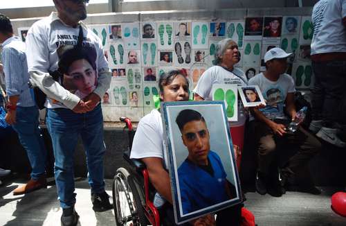 Integrantes del colectivo Hasta Encontrarles colocaron fotografías de personas desaparecidas afuera de la FGR.