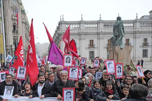 El presidente chileno, Gabriel Boric (parte inferior a la izquierda), participó ayer en la marcha en Santiago por el 50 aniversario del golpe al presidente Salvador Allende, cuya estatua se alcanza a ver al fondo. El gobierno de EU, por conducto del entonces secretario de Estado, Henry Kissinger, ayudó a derrocar al mandatario socialista por considerar que el pueblo que lo eligió democráticamente fue “irresponsable”.