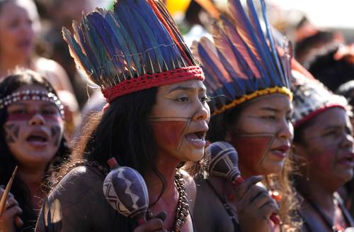 Miles de mujeres indígenas de todo Brasil, muchas ataviadas con coronas de plumas tradicionales, marcharon ayer en la capital de ese país para protestar contra una propuesta en la Corte Suprema que limita sus derechos sobre territorios ancestrales. En el Supremo Tribunal Federal se tramita un juicio por el “marco temporal”, una tesis que sólo reconoce a los indígenas derechos sobre los territorios que ocupaban cuando se promulgó la Constitución de 1988. Si la Corte valida esta tesis, defendida por el poderoso lobby agrícola, perjudicaría la política del presidente izquierdista Luiz Inácio Lula da Silva de demarcación de reservas indígenas, consideradas por expertos como grandes barreras contra la deforestación. Más de 5 mil mujeres marcharon desde la Explanada de los Ministerios, en el corazón político de Brasilia, portando pancartas en las que se leían frases como “Nuestra historia no empieza en 1988” y “Resistir para existir”.