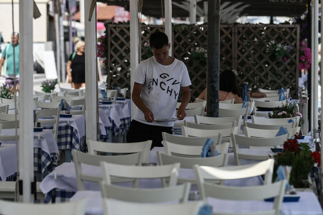 Un camarero prepara las mesas en un restaurante cerca de la playa en la península de Calcídica, al norte de Grecia, el 13 de junio de 2025. Foto