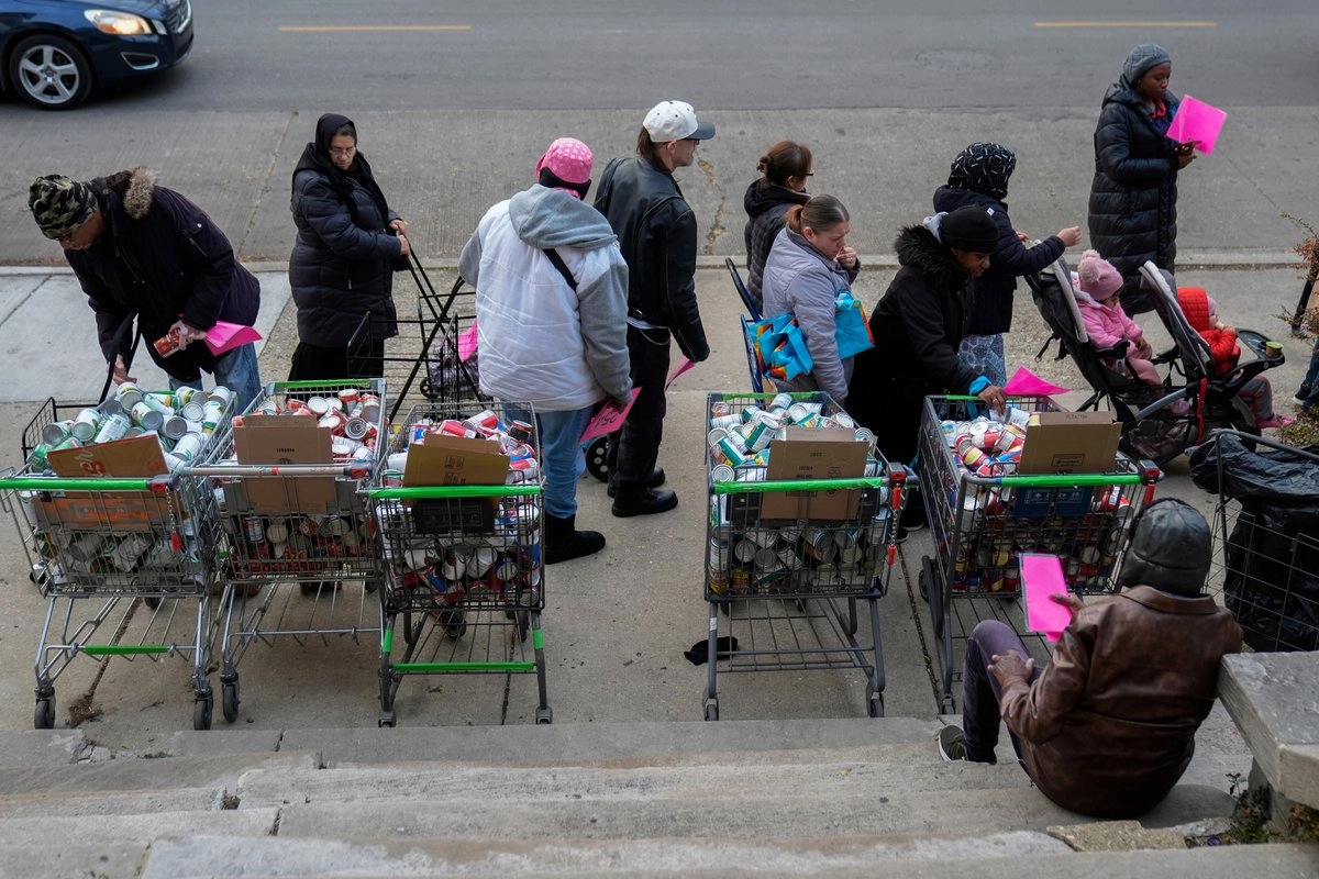 Personas hacen fila para recoger alimentos donados en la sede de Care for Real en Rogers Park, el jueves 13 de noviembre de 2025, en Chicago. Foto