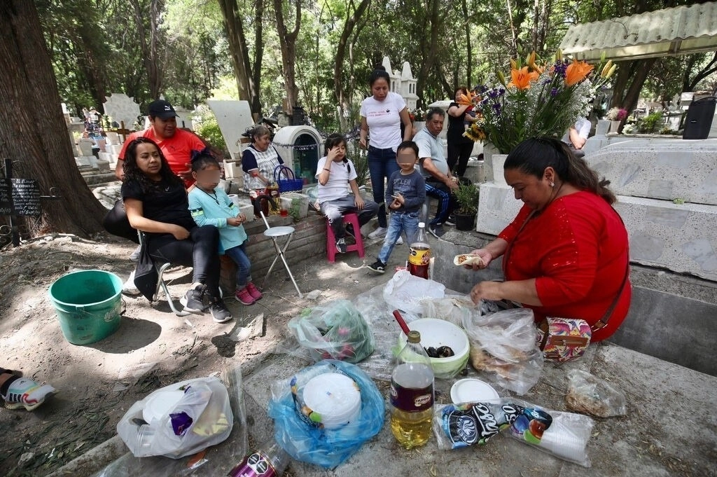 Capitalinos acudieron a los panteones de la ciudad para llevar ofrendas a sus madres ausentes. En esta imagen, una familia llevó comida y bebidas y aprovechó para hacer un picnic. Foto Luis Castillo