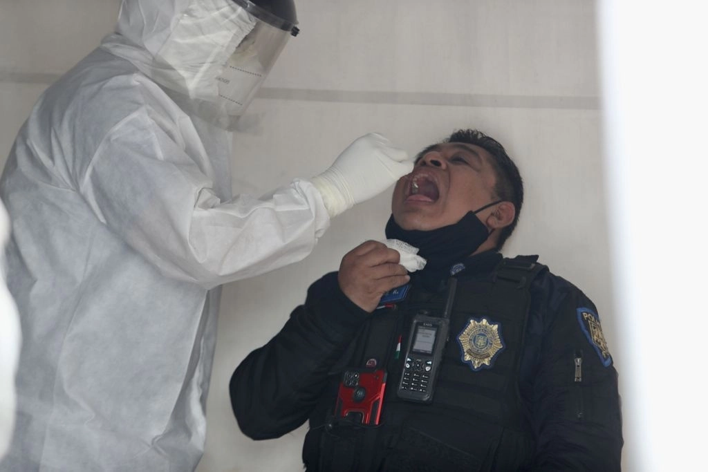 Personal de salud aplica una prueba de Covid-19 a un elemento de policíaco en la alcaldía Venustiano Carranza. Foto Yazmín Ortega