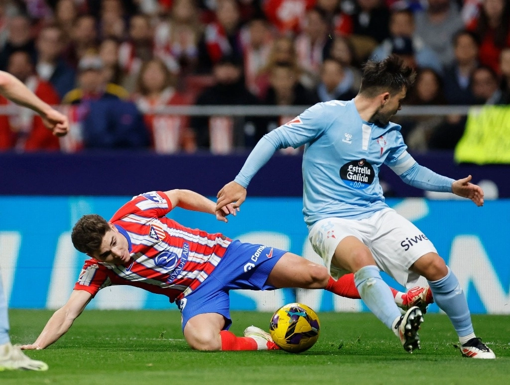 Julián Álvarez del ‘Atleti’ defiende el esférico ante Fran Beltrán del Celta de Vigo durante el juego de la fecha 24 de La Liga, en el Estadio Metropolitano de Madrid, el 15 de febrero de 2025. Foto Afp

