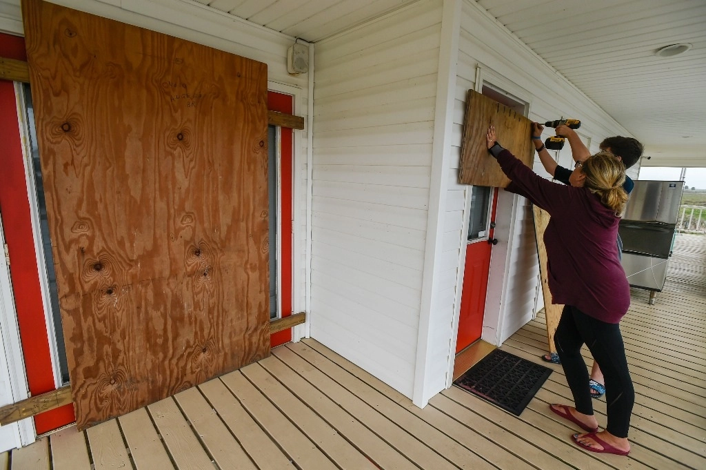 Los residentes de Luisiana colocan madera en la puerta de su casa mientras se preparan para la llegada del huracán ‘Delta’. Foto Ap