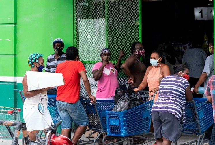 Personas realizando compras ante la inminente llegada de 'Nana' a Belice. Foto Afp