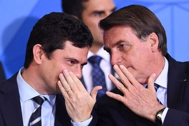 El presidente Jair Bolsonaro (derecha) y su entonces ministro de Justicia, Sergio Moro, dialogan durante una reunión de gabinete en Brasilia, en agosto de 2019. Foto Afp