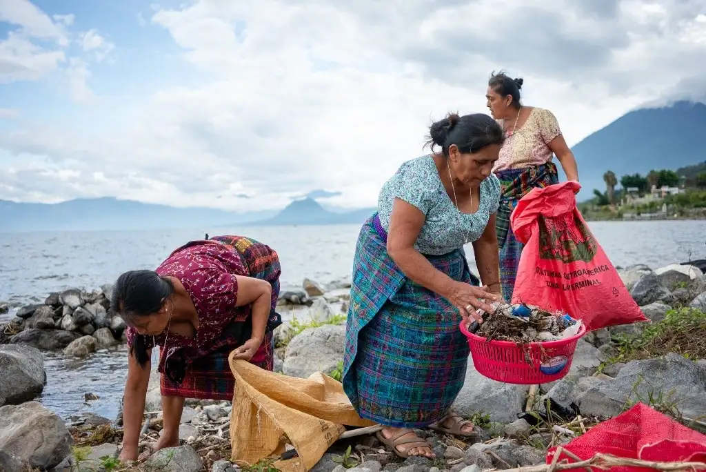 Mujeres indígenas de la comunidad Tz'unun Ya', consideradas "guardianas del lago", realizan labores de limpieza en el lago Atitlán, en Guatemala. Foto Afp   