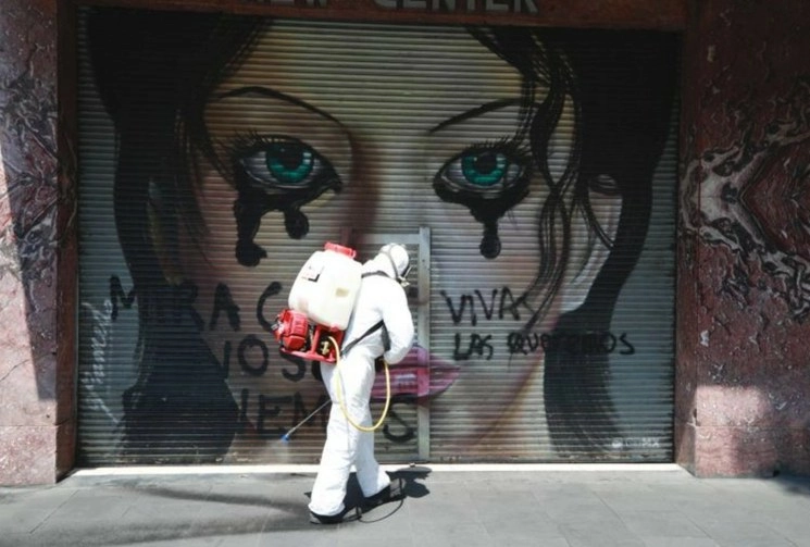Un trabajador del Gobierno de la Ciudad de México sanitiza la avenida 20 de noviembre, en el Centro Histórico. Foto Alfredo Domínguez