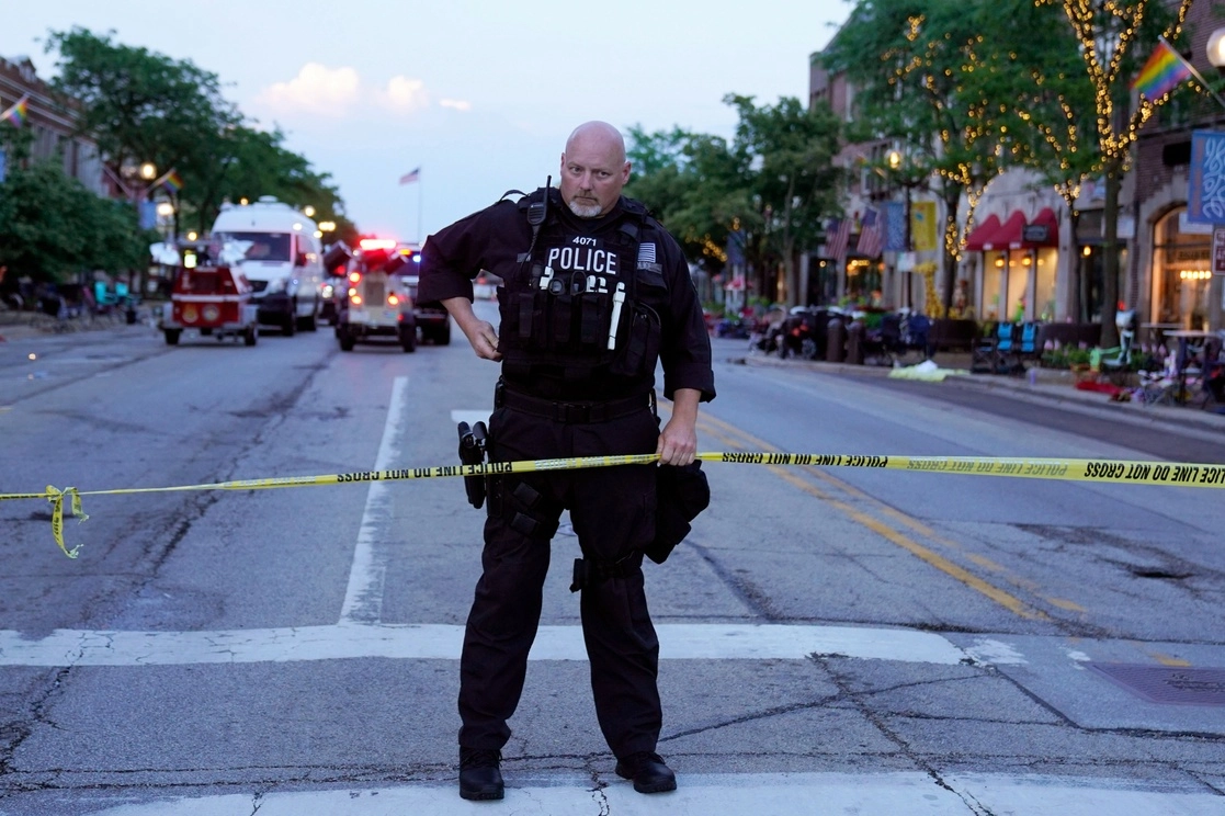 Un oficial de policía sostiene una cinta que resguarda la escena de un tiroteo masivo en el desfile del 4 de julio de Highland Park, Chicago, el lunes 4 de julio de 2022. Foto Ap