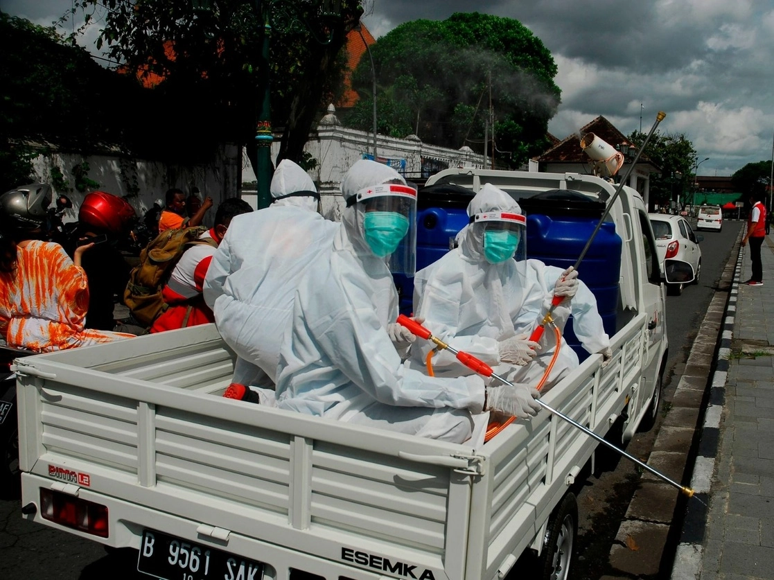 Trabajadores de Salud realizan trabajos de sanitización para evitar el esparcimiento del Covid-19 en calles de Yogyakarta, Indonesia. Foto Afp