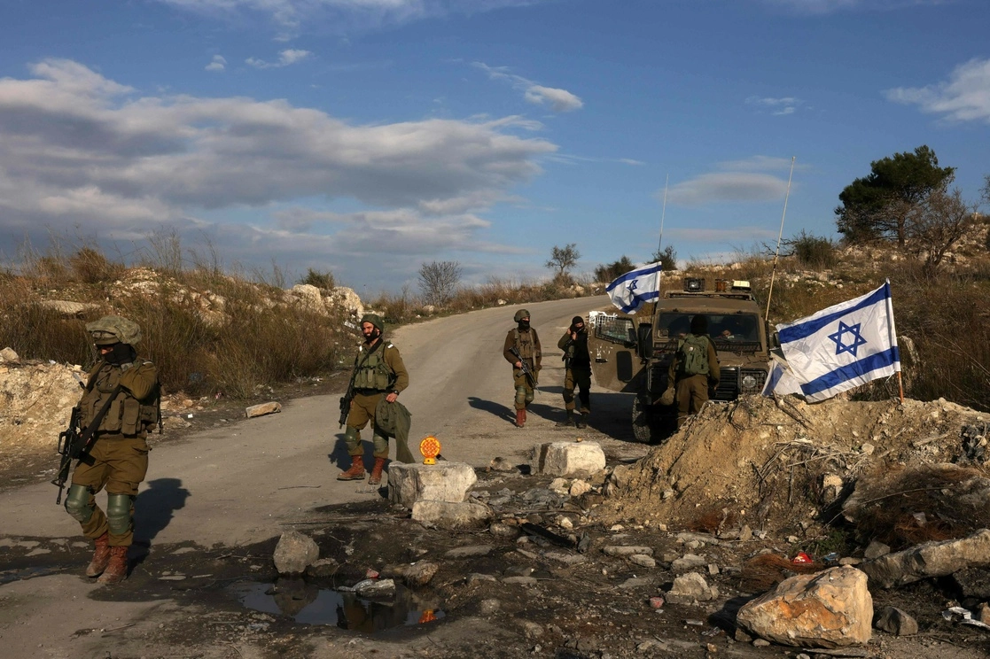 Soldados israelíes resguardan una carretera al oeste de Nablus, ciudad de Cisjordania. Foto Afp