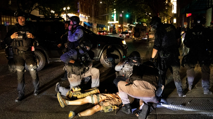 Policías auxilian a un hombre herido durante una protesta en Portland, Oregon, el pasado 29 de agosto; después falleció. Foto Ap