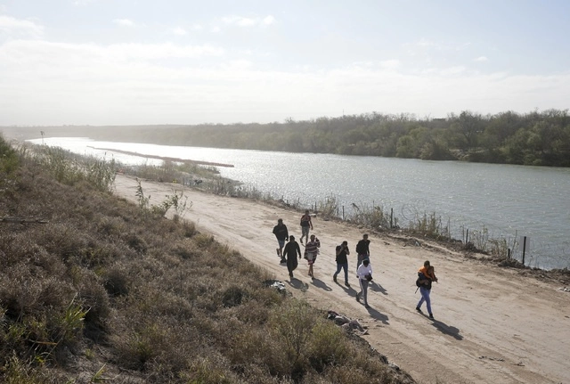 Un grupo de migrantes venezolanos caminan por la orilla del Río Bravo para entregarse a la Patrulla Fronteriza de EU luego de ingresar a Eagle Pass. Foto Ap
