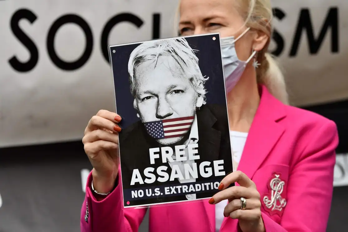 Una manifestante sostiene una pancarta de apoyo a Julian Assange afuera de los Reales Tribunales de Justicia en Londres, el 27 de octubre de 2021. Foto Afp 