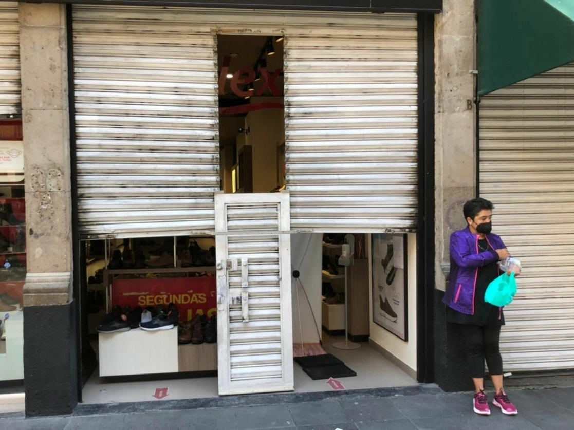 Locales del Centro Histórico de la Ciudad de México ofrecen servicio a media cortina, sólo para entrega de mercancía, el 8 de febrero de 2021. Foto Luis Castillo
