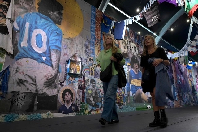 Mujeres recorren la exposición "Diego Eterno", un viaje inmersivo por la vida del astro del fútbol argentino Diego Maradona. Foto Afp