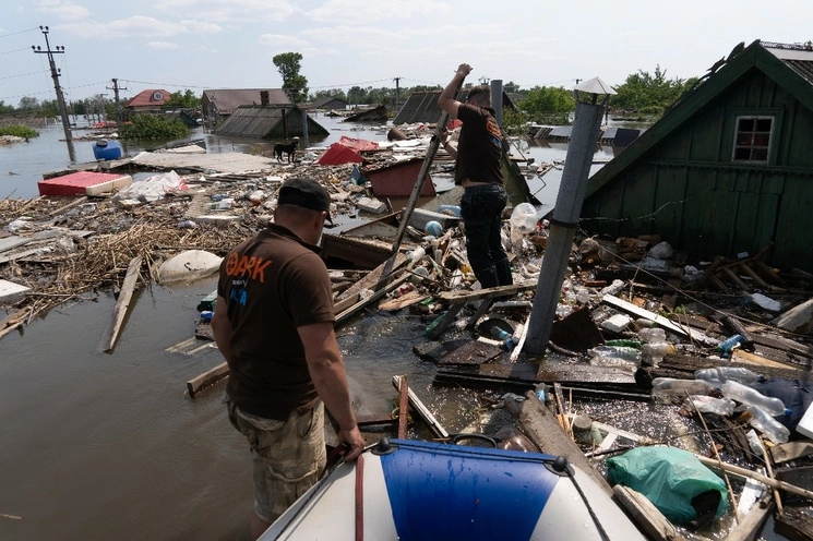 Los rescatistas de animales se abren camino a través de los escombros flotantes para rescatar a un perro en el área inundada después del colapso de la represa en Kherson, Ucrania. Foto Ap