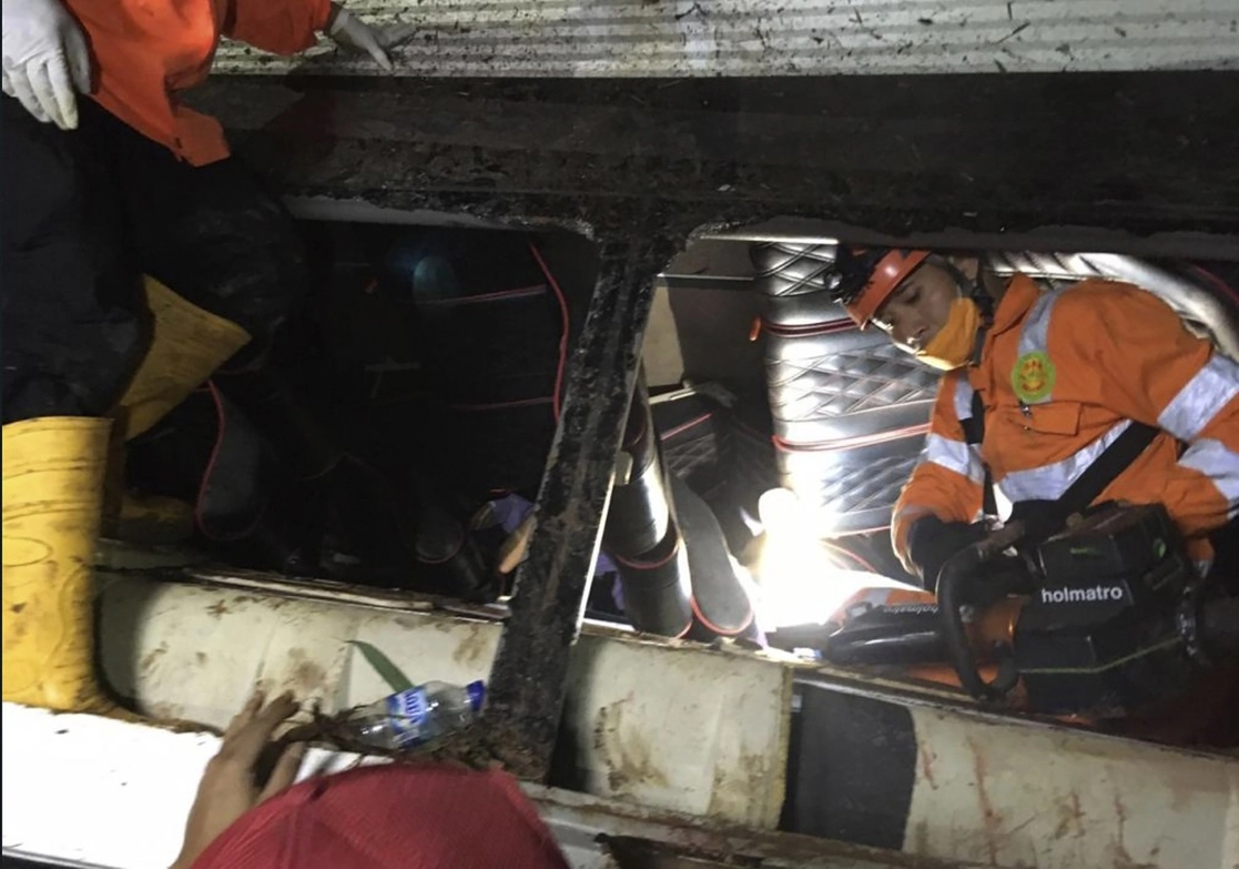 Rescatistas intentan sacar a pasajeros atrapados en el camión. Foto Ap