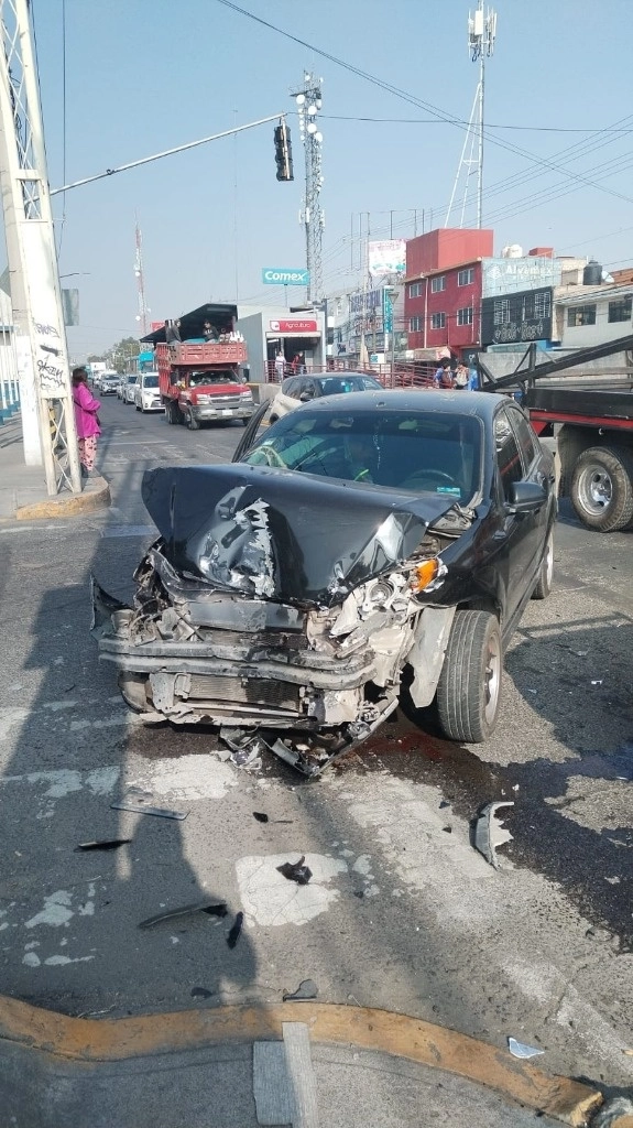 Personal de Protección Civil y Bomberos atendieron a los pasajeros que viajaban en una combi Nissan Urban blanca, y un auto Aveo negro que tuvo derrame de combustible y aceite. Foto La Jornada